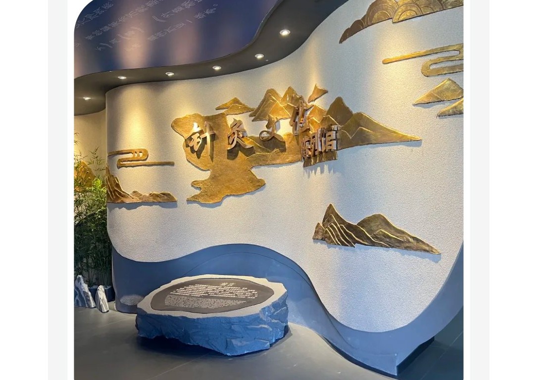 针灸文化陈列馆序厅，金色山水浮雕墙与针灸文化陈列馆标识